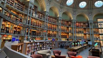 The space of a huge library full of books, tables and chairs for reading